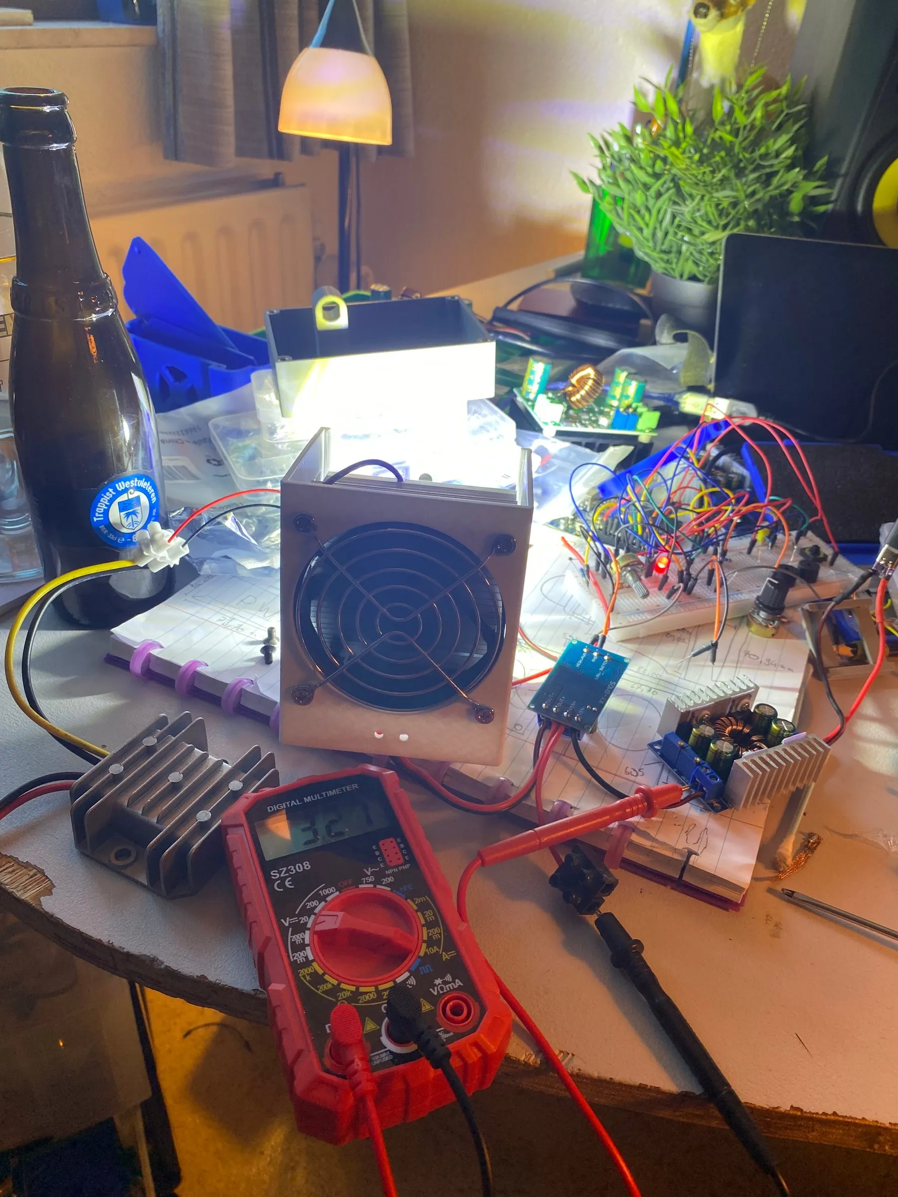 The finished light powered on and glowing brightly on the workbench, beside a multimeter and the breadboard prototype.